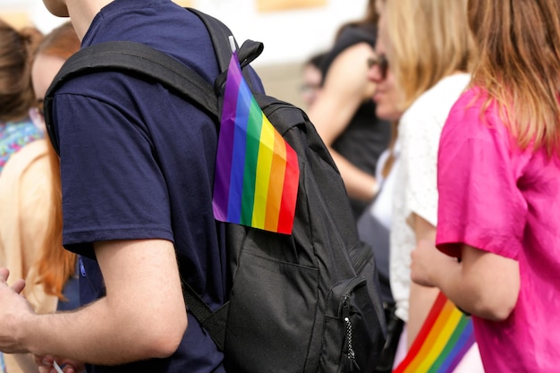 Concept of sexual minority Young man with rainbow flag on his backpack