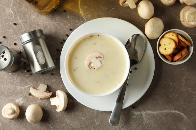 Concept smakelijke lunch met kom champignonsoep op grijs