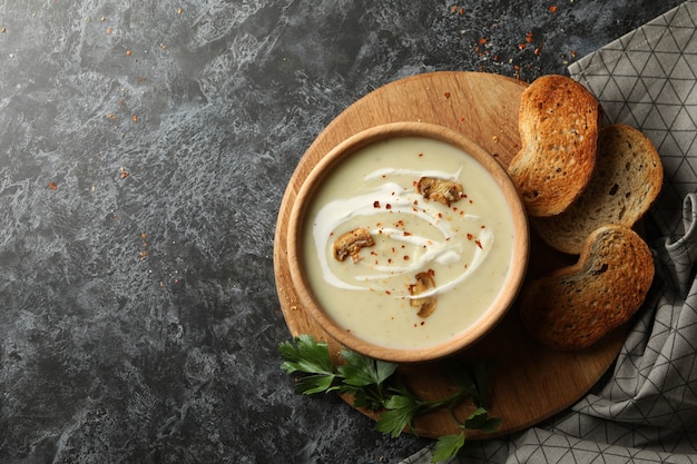 Concept smakelijke lunch met kom champignonsoep op rokerige zwarte