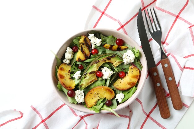 Concept smakelijke salade met geroosterde perzik op witte achtergrond