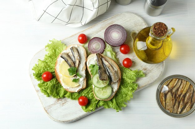 Concept smakelijke snack met sandwiches met sprot op witte houten achtergrond