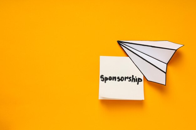 Concept of sponsorship with paper plane on yellow background