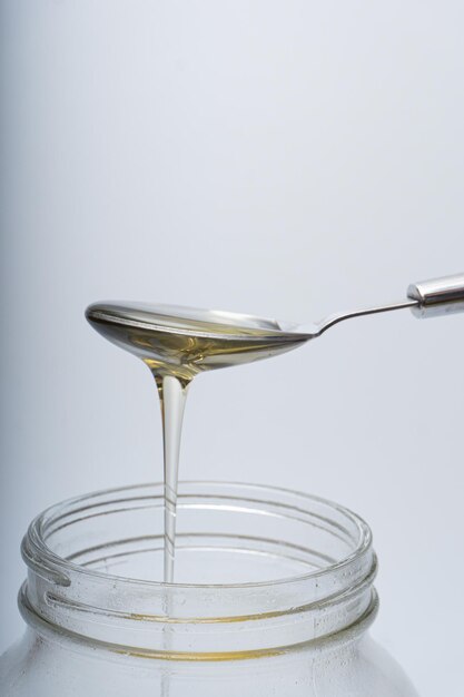 Concept of spooning honey from a bottle