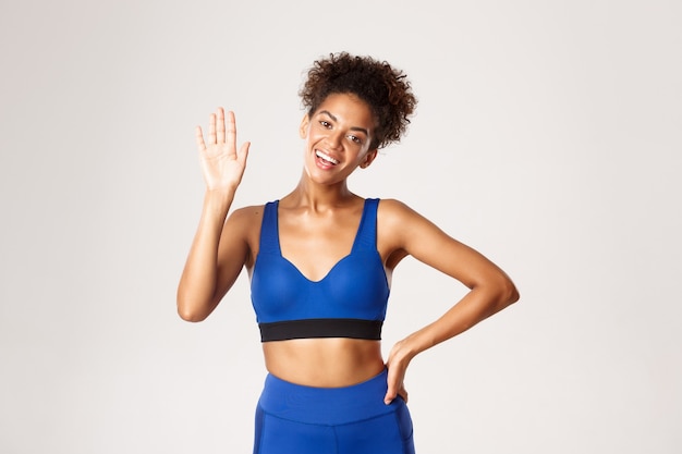 Concetto di sport e allenamento. attraente, atleta femminile afro-americano in buona salute, agitando la mano