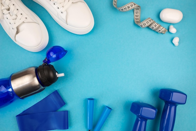 The concept of sports accessories Photo of white sneakers blue dumbbells and a blue exercise mat and other sports equipment