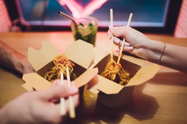 concept of street food chinese japanese noodles with chicken and vegetables in disposable paper