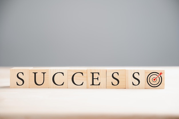 Photo a concept of success depicted by a wooden cube over the word success