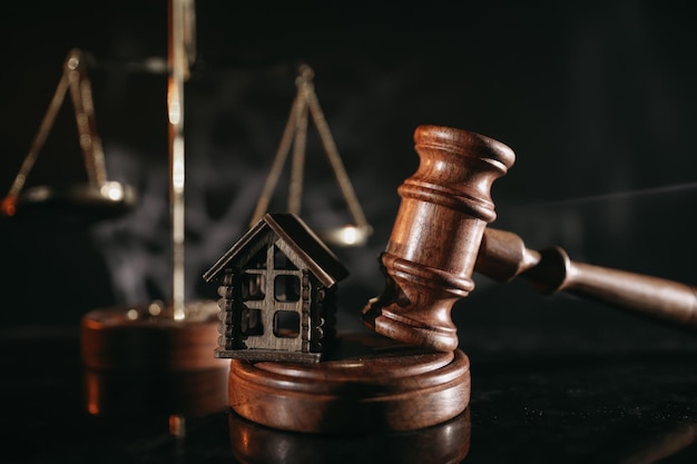 Concept of suing for property. Wooden gavel with house close-up