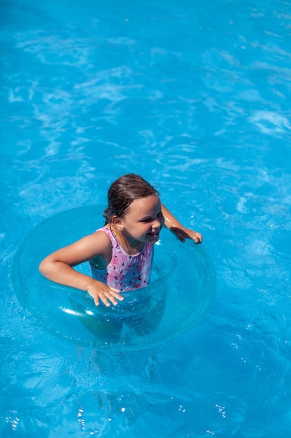 The concept of a summer holiday a cheerful child has a good time in the clean transparent water of t...