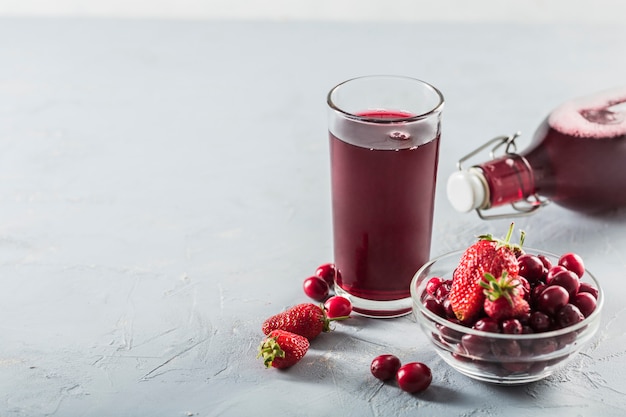 The concept of a summer refreshing drink made from red berries: berry Morse made from fresh strawberries and cranberries