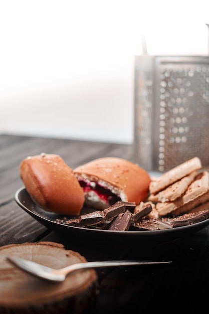 The concept of sweets Cookies chocolate and bun on a wooden table For coffee and tea