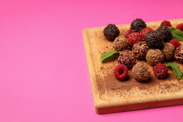 분홍색 배경에 초콜릿 사탕이 있는 과자의 개념