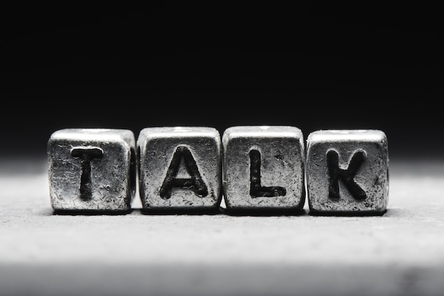 Photo concept talk. the inscription on metal 3d cubes isolated on a black background