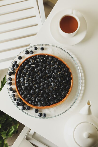 Concept of tasty breakfast with blueberry pie on white table