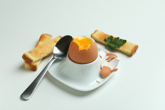 Concept of tasty breakfast with boiled egg on white