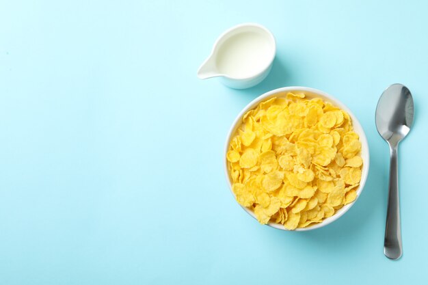 Concept of tasty breakfast with cornflakes on blue background