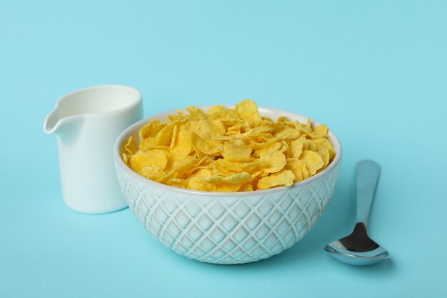 Foto concetto di gustosa colazione con cornflakes su sfondo blu