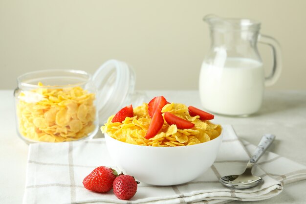 Concept of tasty breakfast with cornflakes on white textured table