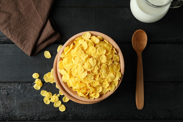 Concept of tasty breakfast with cornflakes on wooden table