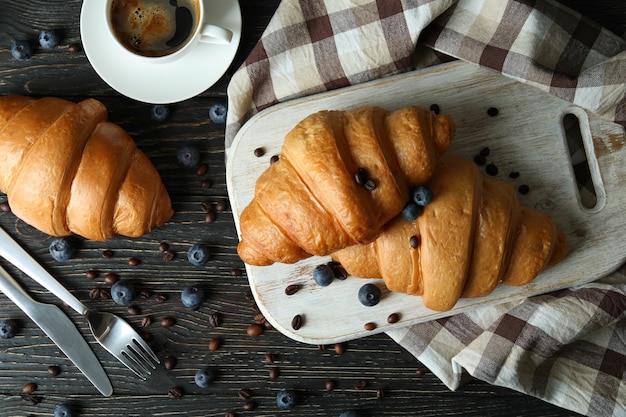 Concept of tasty breakfast with croissants on wooden