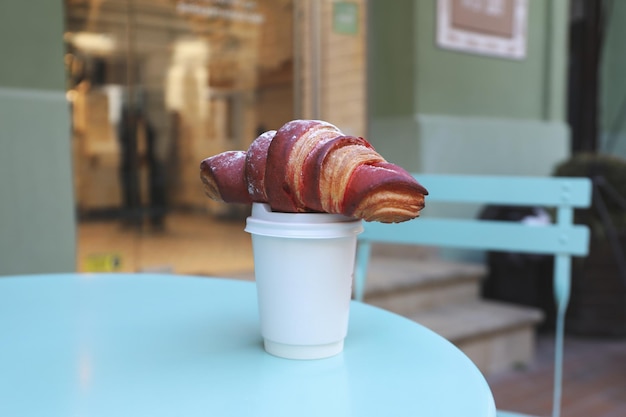 Concetto di gustosa colazione con tazza di caffè e croissant