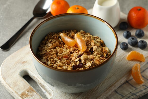 Concept of tasty breakfast with granola on gray background