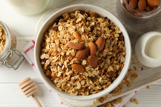 concept of tasty breakfast with granola on white wooden background