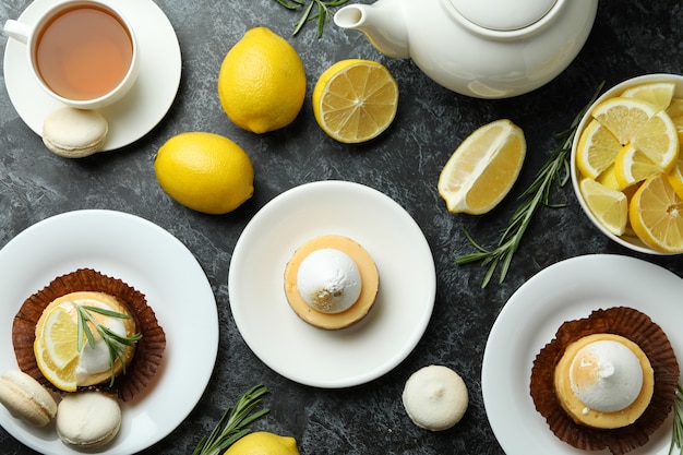 Concept of tasty breakfast with lemon cupcakes and macaroons