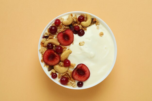 Concept of tasty breakfast with yogurt on beige background