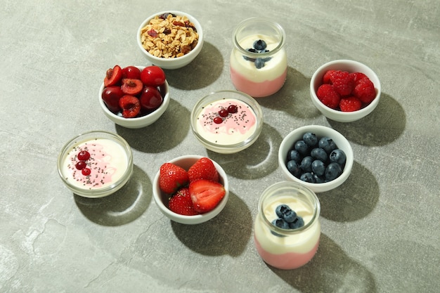 Concept of tasty breakfast with yogurt on gray textured table