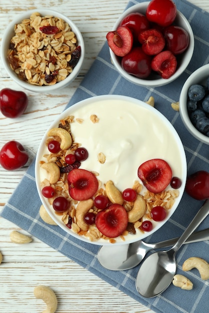 Concept of tasty breakfast with yogurt on wooden table