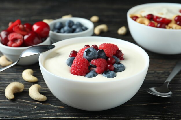 Concept of tasty breakfast with yogurt on wooden table