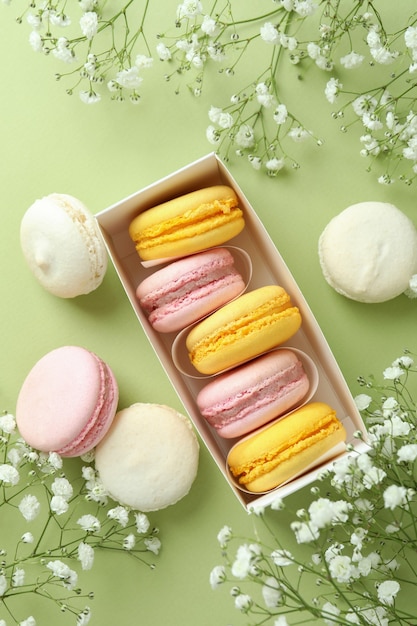 Concept of tasty dessert with macaroons on green background