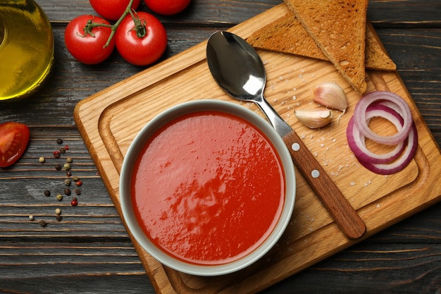 Concept of tasty dinner with tomato soup on wooden