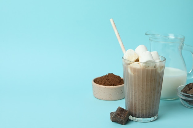 Concept of tasty drink with cocoa on blue background