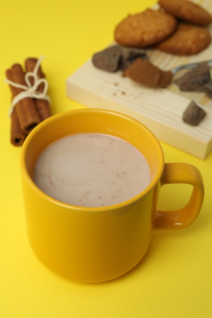 Concept of tasty drink with cocoa on yellow background