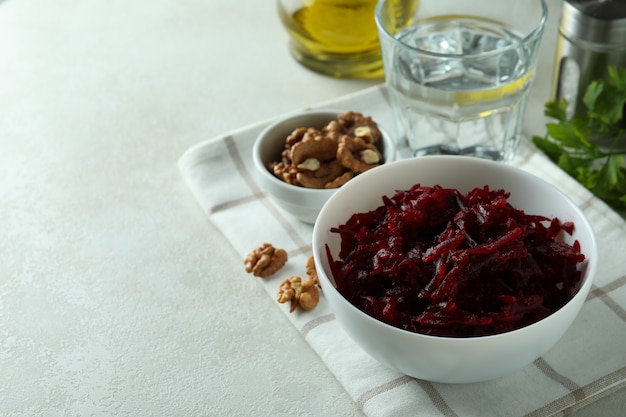 Concept of tasty eating with bowl of beet salad on white textured table