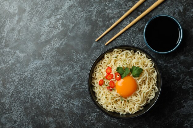 Concept of tasty eating with bowl of noodles on black smokey