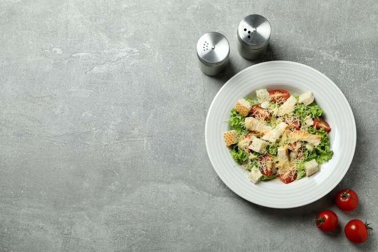 Фотография концепция вкусной еды с салатом цезарь на сером