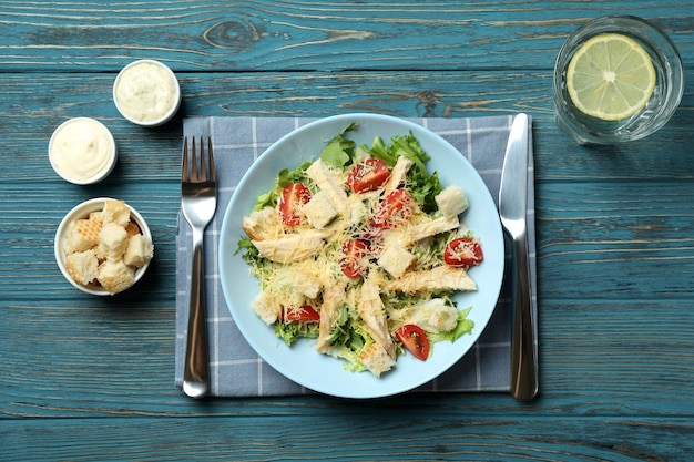 Concept of tasty eating with Caesar salad on wooden table