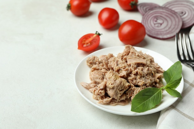 Concept of tasty eating with canned tuna on white textured background