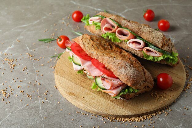 Концепция вкусной еды с бутербродами чиабатта на сером текстурированном столе