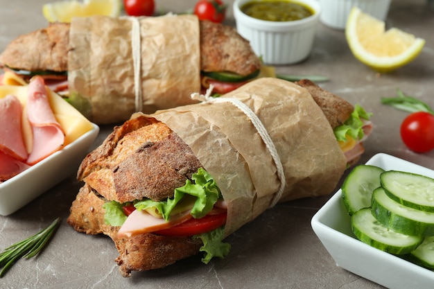 Concept of tasty eating with ciabatta sandwiches on gray textured table