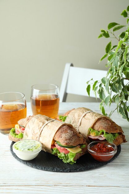 Concept of tasty eating with ciabatta sandwiches on white wooden table