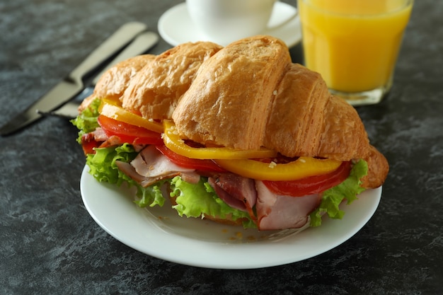 Concetto di gustoso mangiare con panino croissant, da vicino