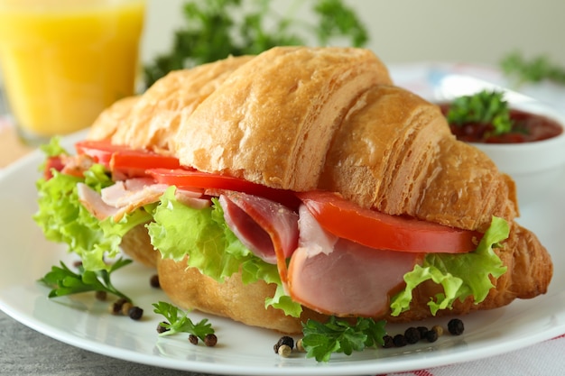 Concept of tasty eating with croissant sandwich, close up