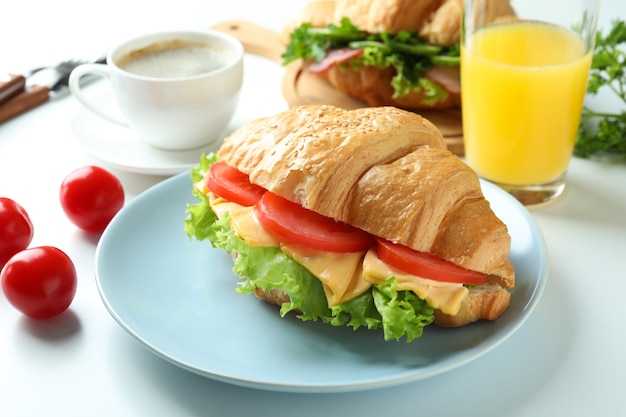 Concept of tasty eating with croissant sandwich, close up