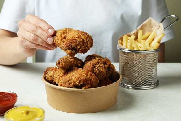 Concept of tasty eating with fried chicken on white textured table