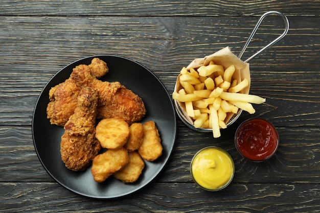 Concept of tasty eating with fried chicken on wooden background