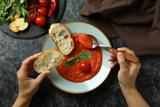 Concept of tasty eating with Gazpacho soup on black smokey background